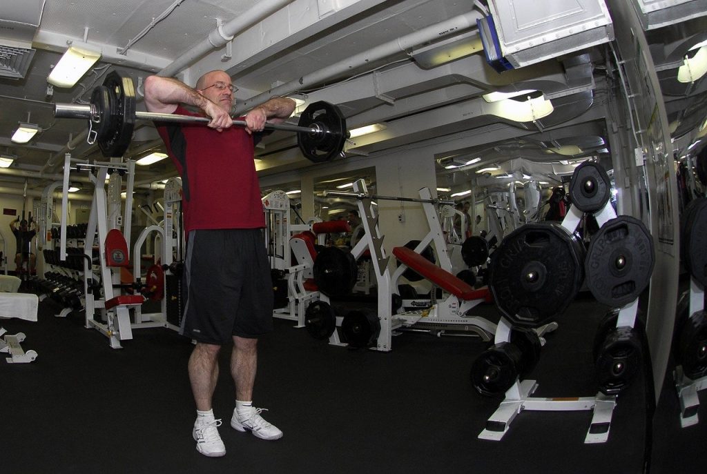 homme senior entrain de suivre un programme de fitness en salle de gym